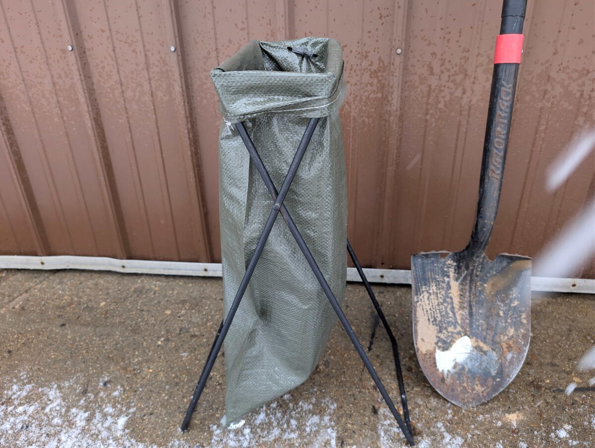A bag cuffed over the stand next to a shovel