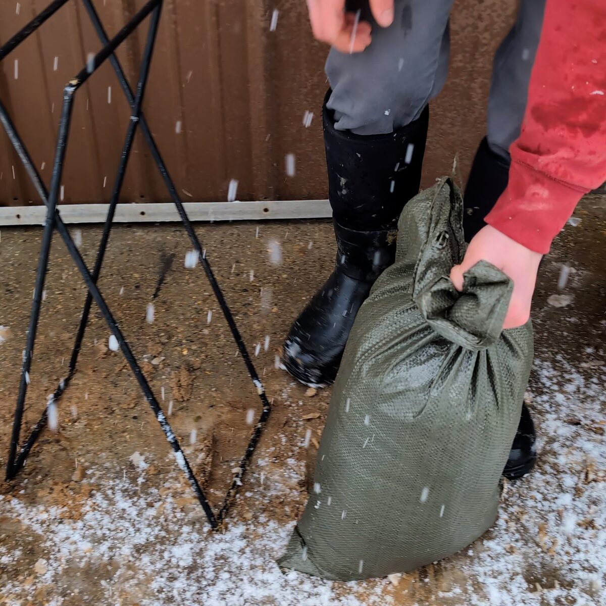Lifting the tied bag away from the empty stand